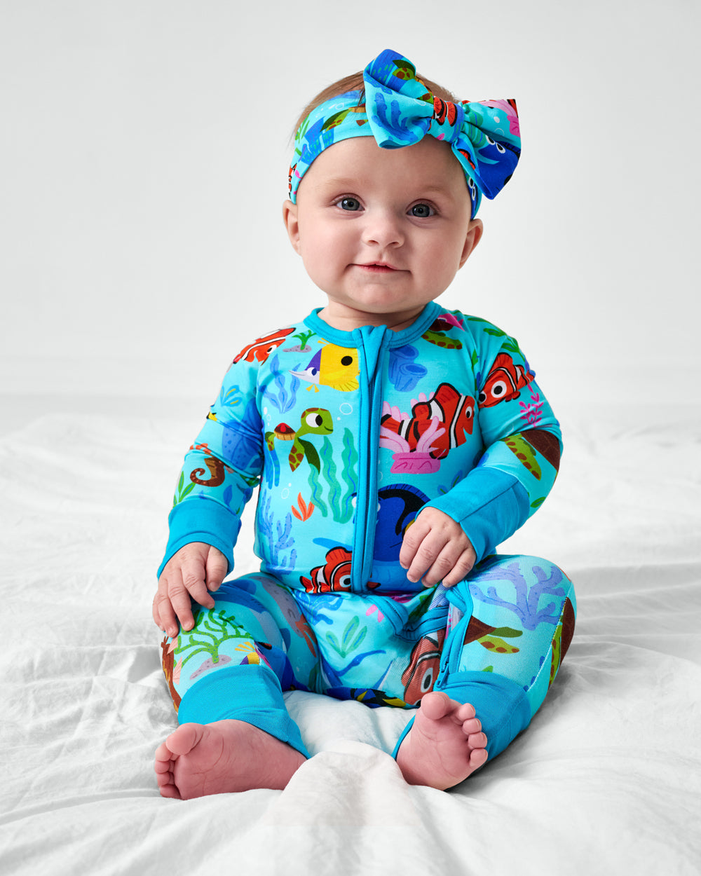 Sitting child wearing the Disney Nemo's Reef Luxe Bow Headband