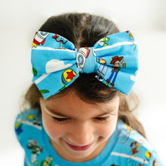 Close up image of a child wearing a Disney Pixar Toy Story Pals luxe bow headband