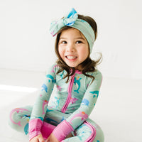 Child wearing a Dolphin Dance luxe bow headband and matching zippy