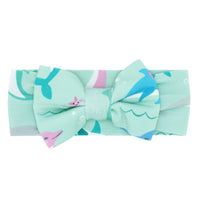 Flat lay image of a Dolphin Dance luxe bow headband
