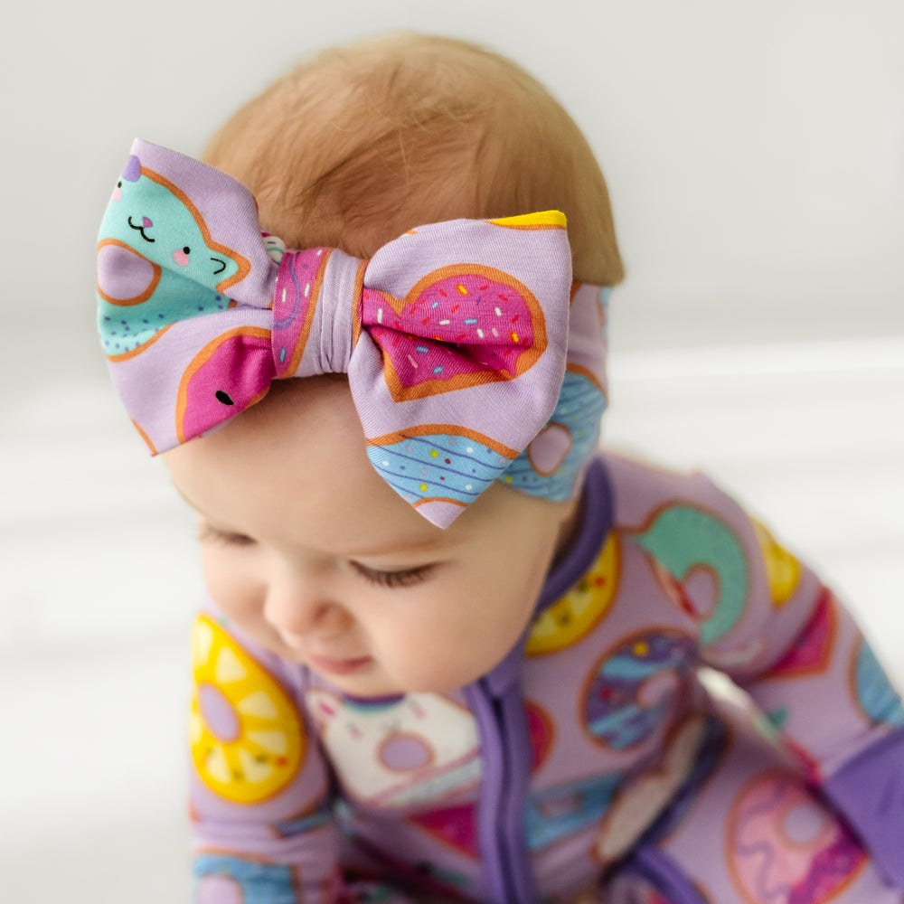 Click to see full screen - Close up image of a child wearing a Lavender Donut Dreams luxe bow headband 