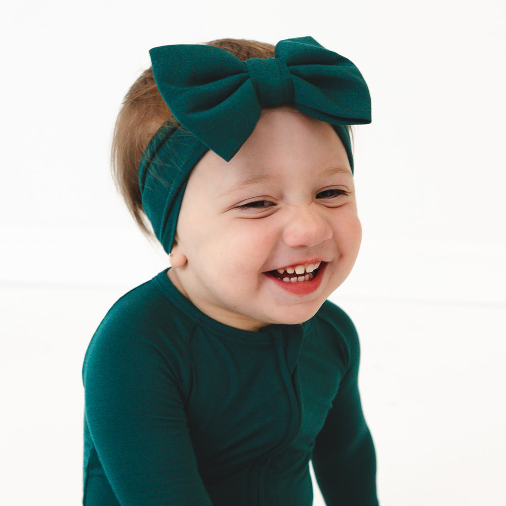 Close up image of child wearing the Emerald Luxe Bow Headband