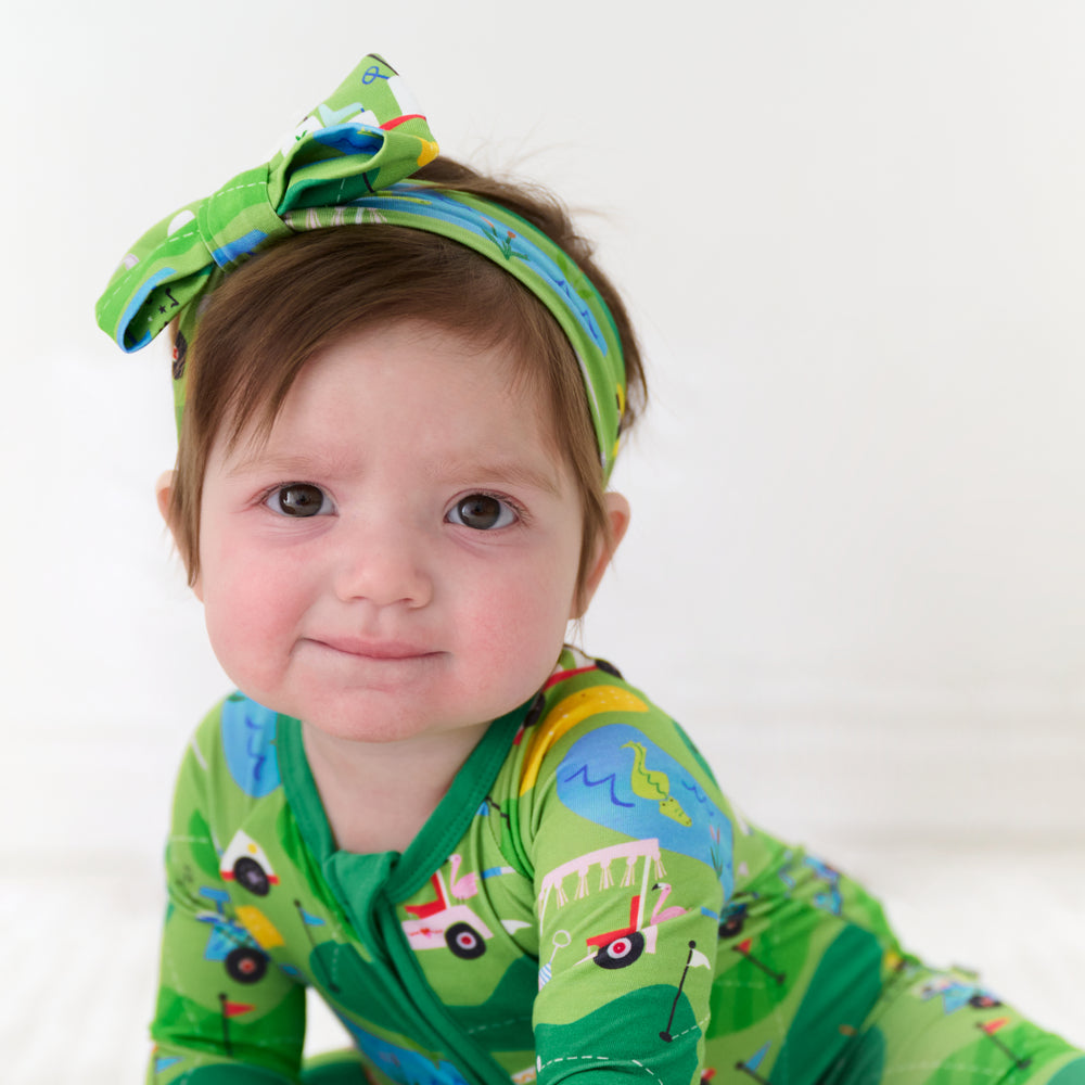 Child wearing a Fairway Fun luxe bow headband and matching zippy