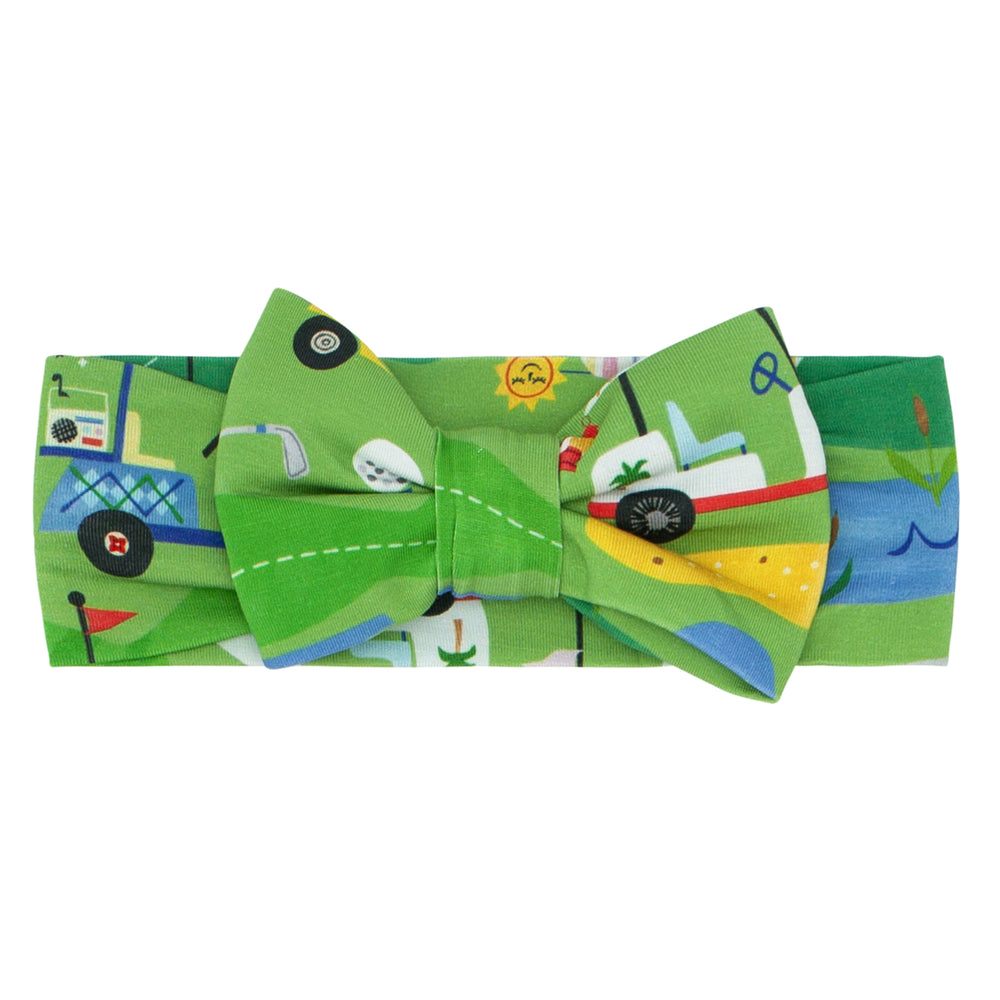 Flat lay image of a Fairway Fun luxe bow headband