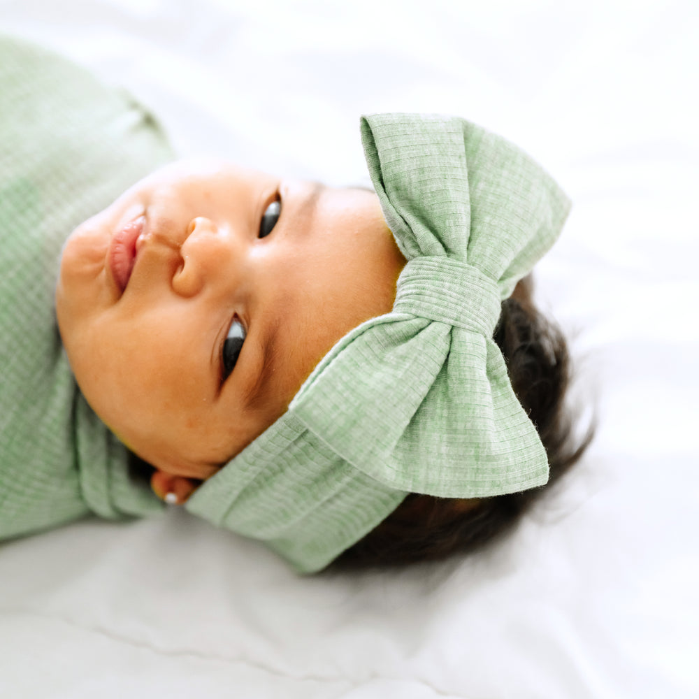 Alternate close up image of a child wearing a Heather Sage ribbed luxe bow headband