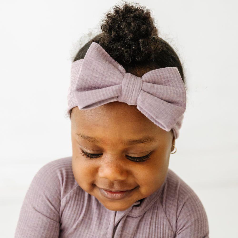 Click to see full screen - Close up image of child wearing a Heather Smokey Lavender Ribbed luxe bow headband