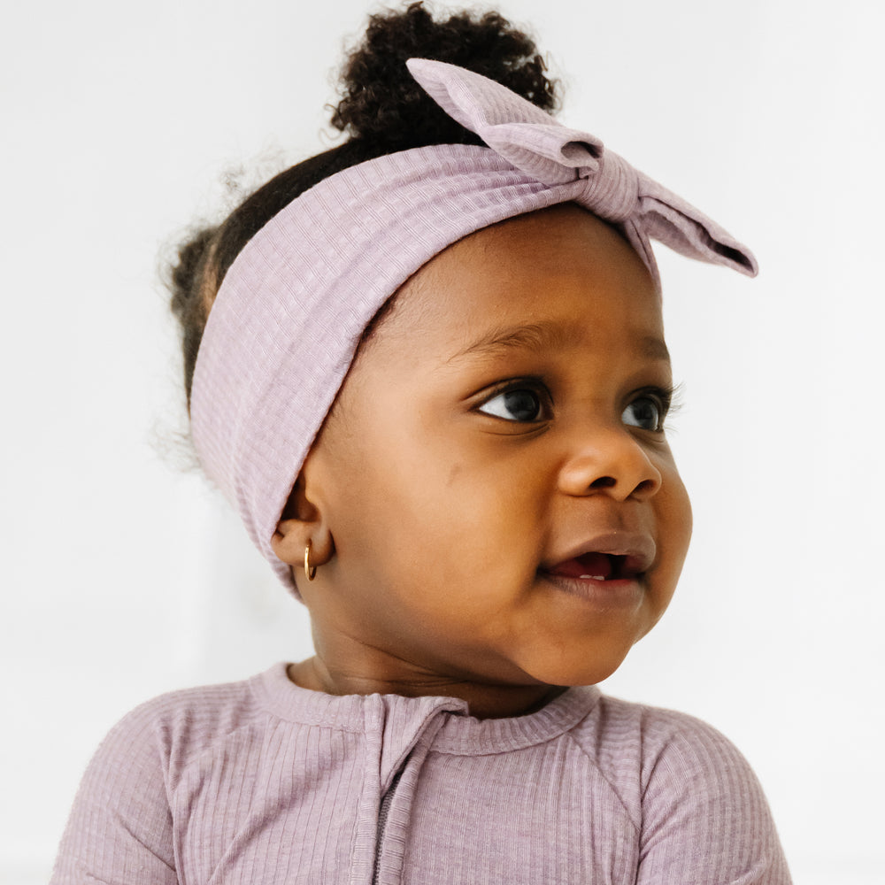 Click to see full screen - Close up profile view of child wearing a Heather Smokey Lavender Ribbed luxe bow headband
