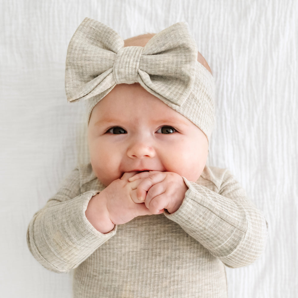 Close up image of a child wearing a Heather Stone Ribbed luxe bow headband
