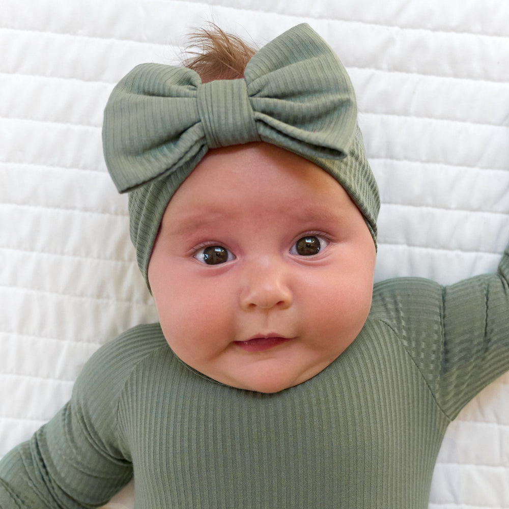 Close up image of baby wearing the Moss Ribbed Luxe Bow Headband