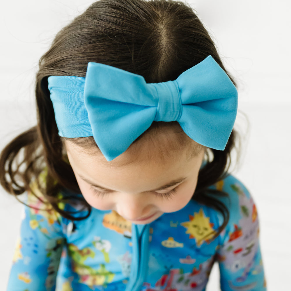Close up image of a child wearing an Ocean Blue luxe bow headband