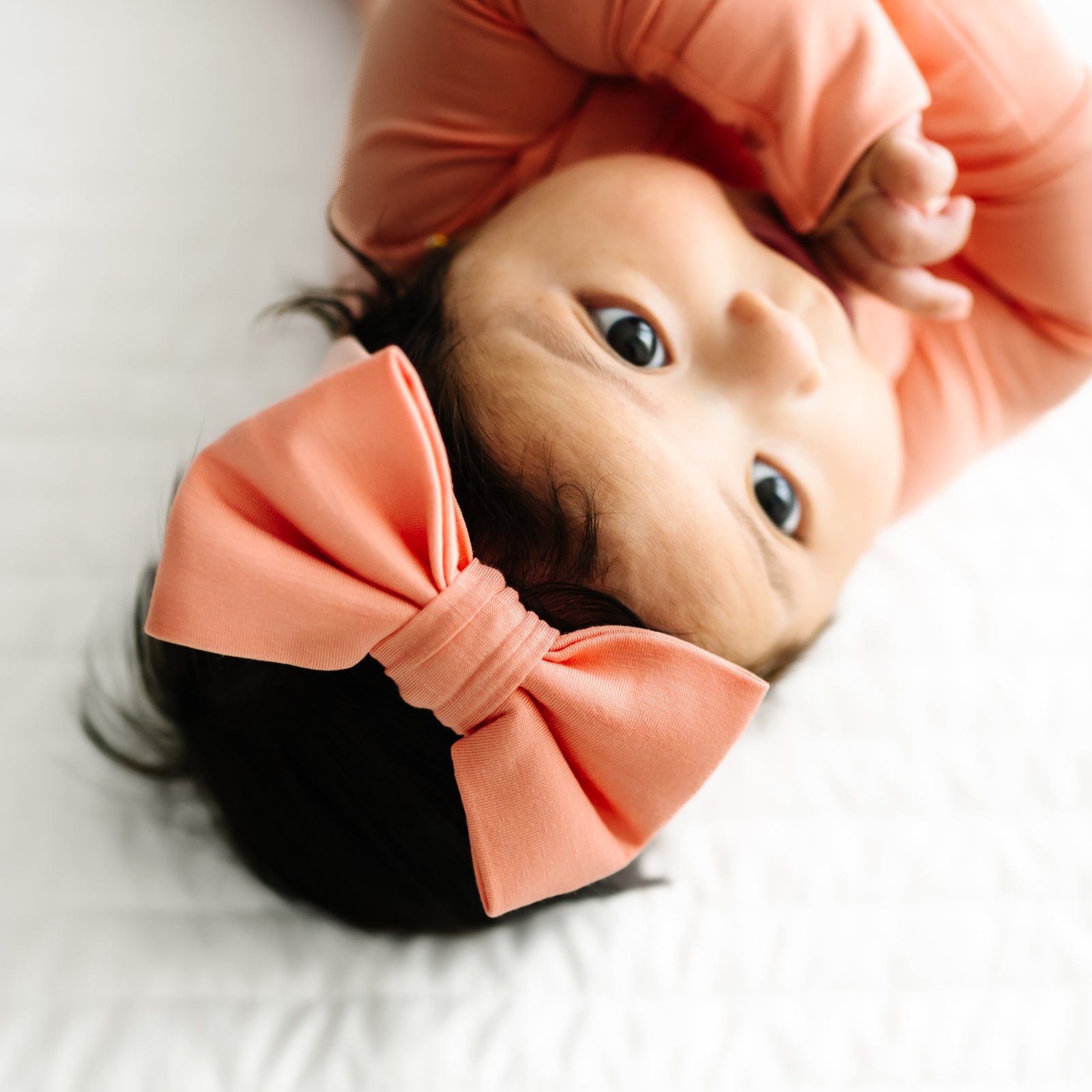 Alternate close up image of a child wearing a Peach Luxe Bow Headband