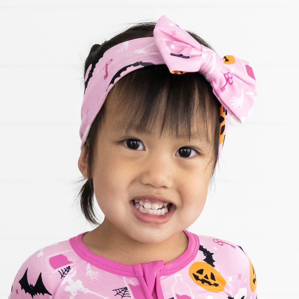 Close up image of girl in the Pink Glowing Ghouls Luxe Bow Headband