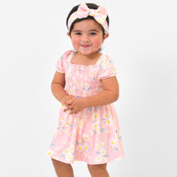 Child wearing a Rosy Meadow luxe bow headband and matching dress
