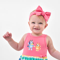Child wearing a Sweet Pink luxe bow headband and coordinating dress