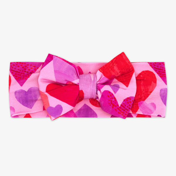 Flat lay image of a Pink Hearts and Crafts luxe bow headband