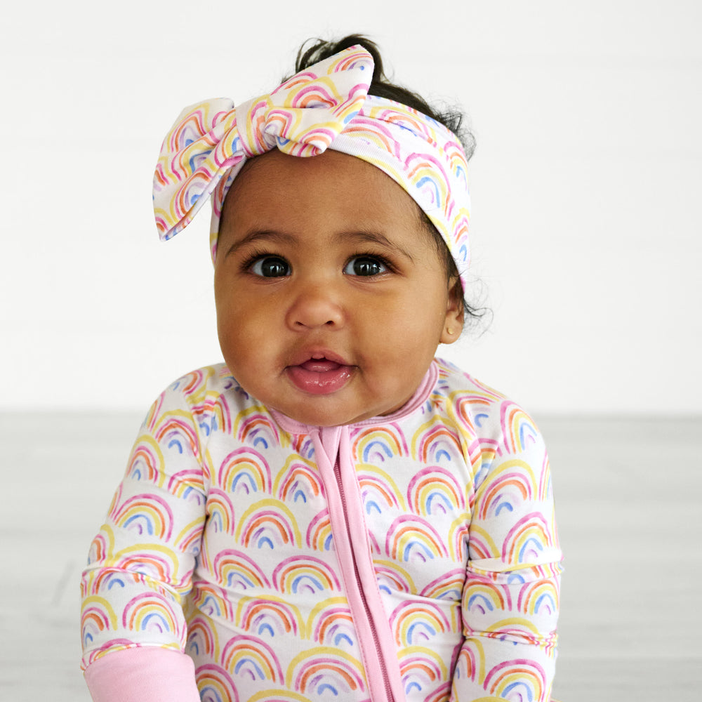 baby facing camera wearing pastel rainbows luxe bow