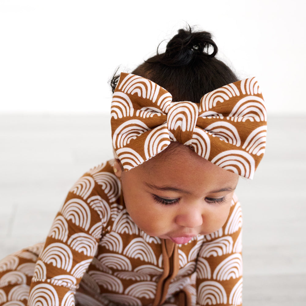 baby looking down wearing the rust rainbows luxe bow