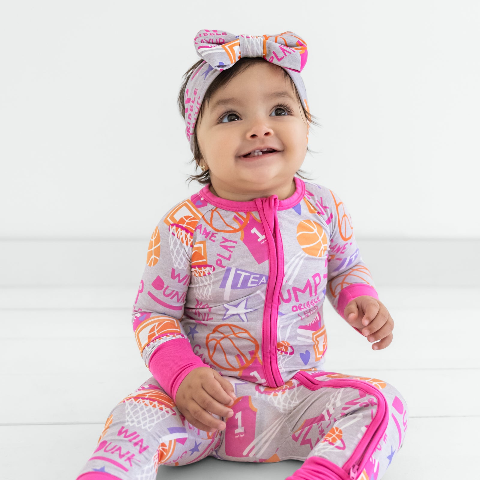 Child wearing the Pink Slam Dunk Luxe Bow Headband and matching pajamas
