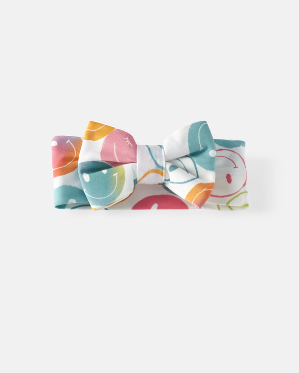 Flat lay of the Positive Vibes Luxe Bow Headband