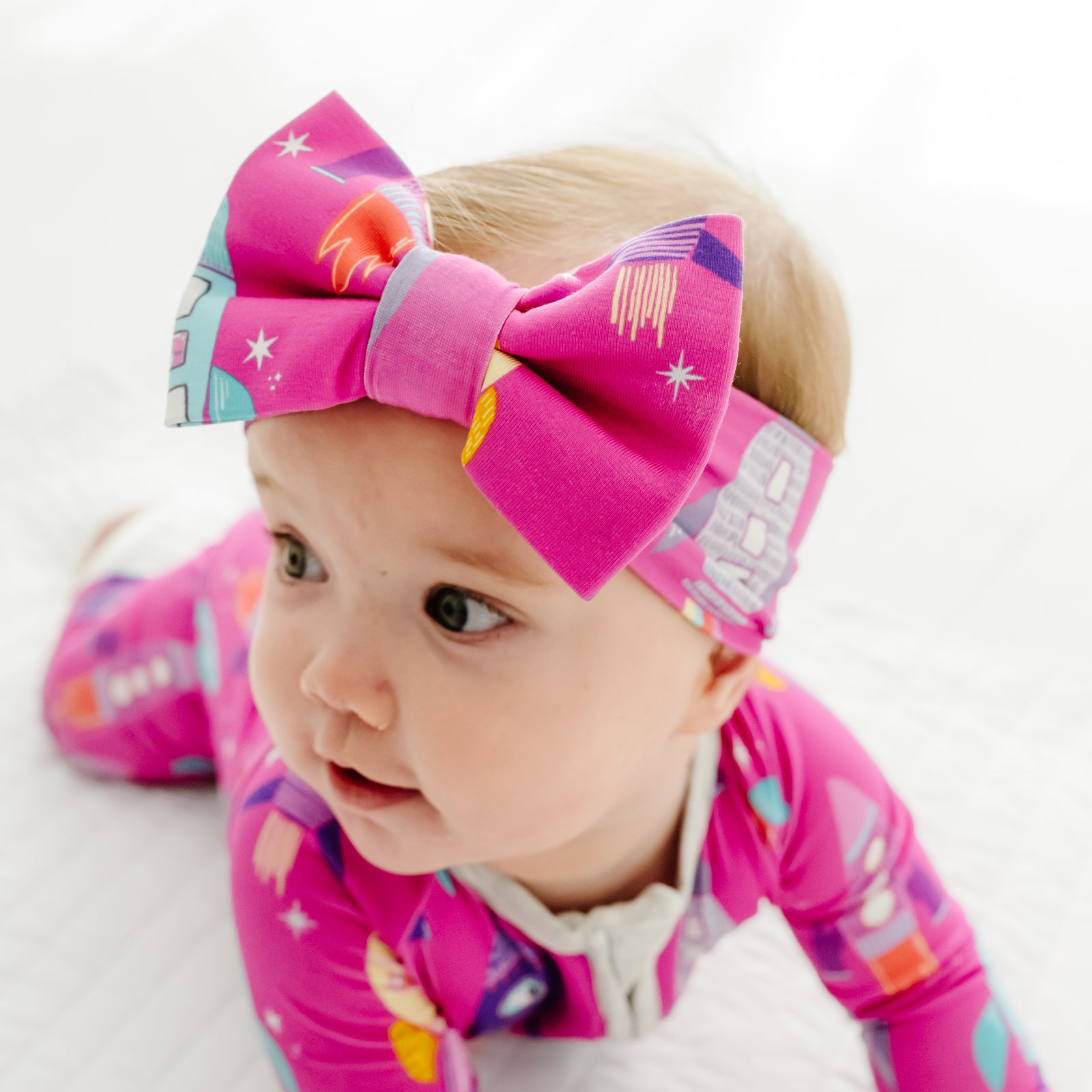 Close up image of a child wearing a Pink Space Explorer luxe bow headband