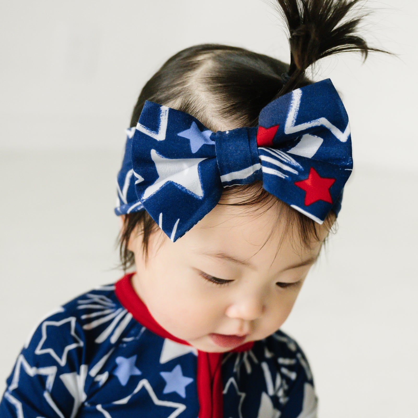Close up image of a child wearing a Star Spangled luxe bow headband