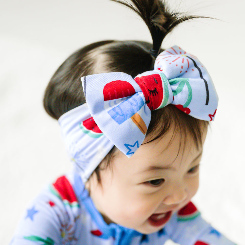 Close up image of a child wearing a Stars, Stripes, and Sweets luxe bow headband