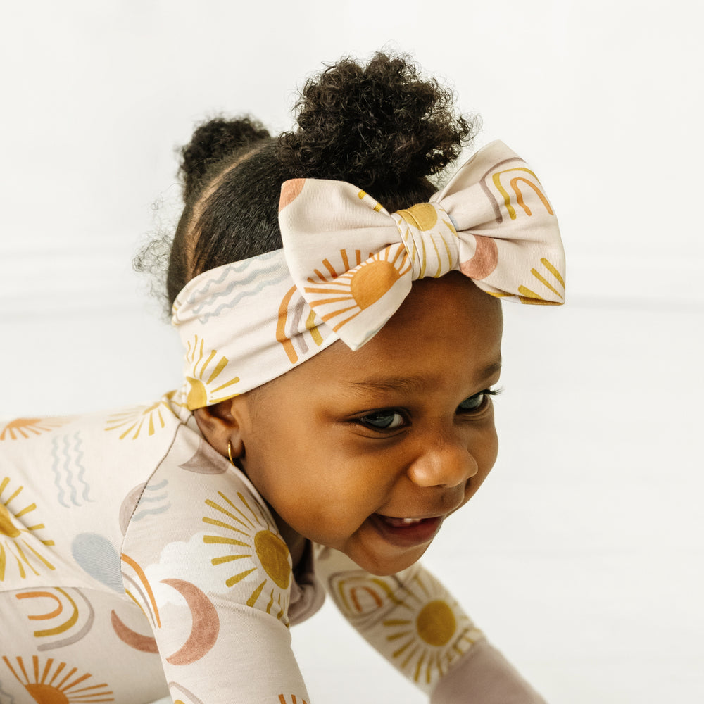 Click to see full screen - Profile close up image of a child wearing a Desert Sunrise luxe bow headband