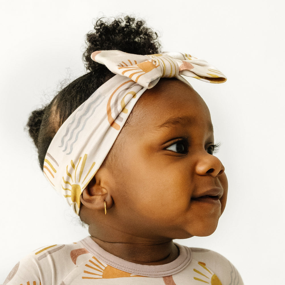 Click to see full screen - Close up image of a child wearing a Desert Sunrise luxe bow headband