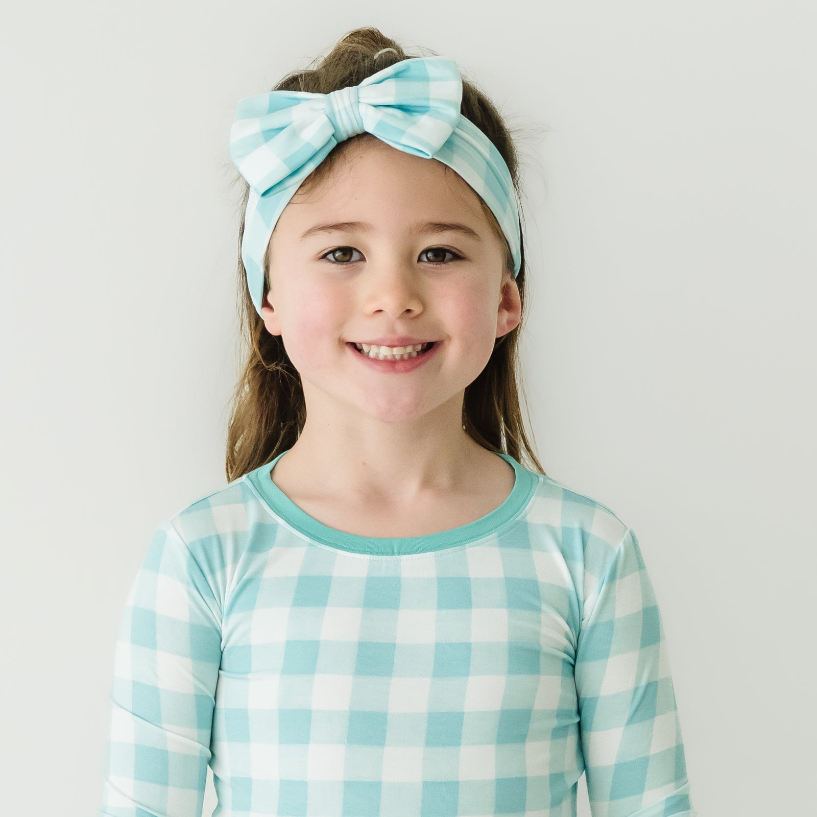 Alternate close up image of a child wearing an Aqua Gingham luxe bow headband