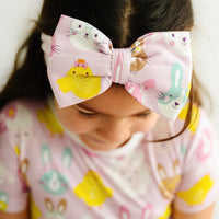 Close up image of a child wearing a Pink Pastel Parade luxe bow headband