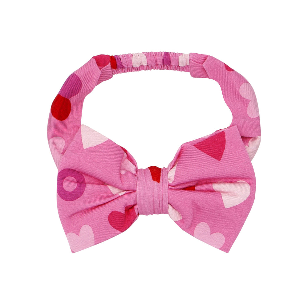 Click to see full screen - Flat lay image of Pink XOXO luxe bow headband in size age 4 to age 8