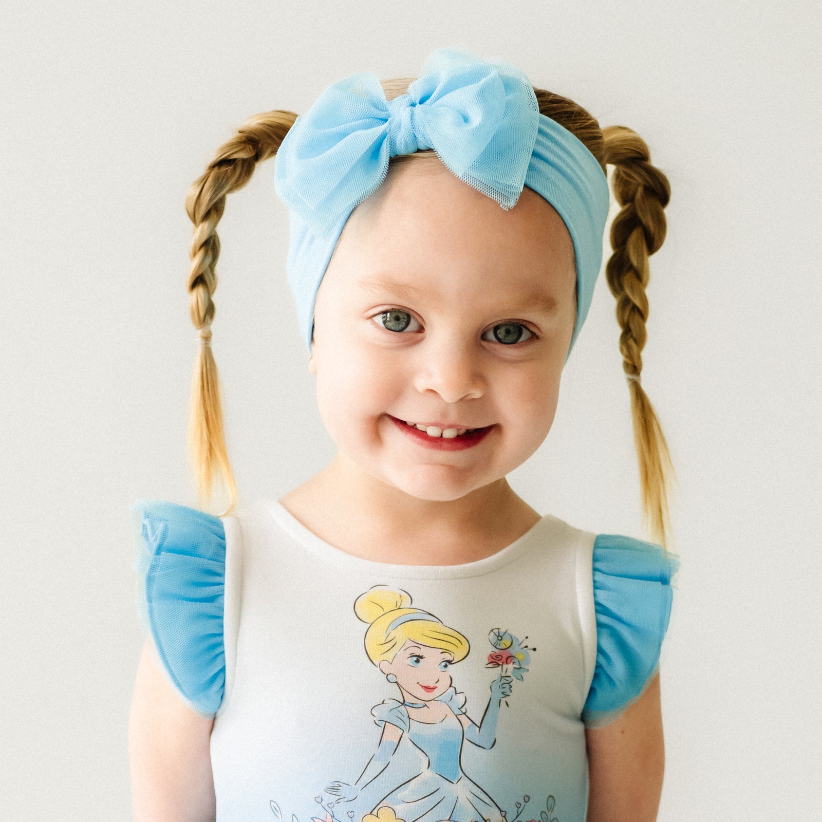 Alternate close up image of a child wearing a Blue tulle luxe bow headband and coordinating Play dress