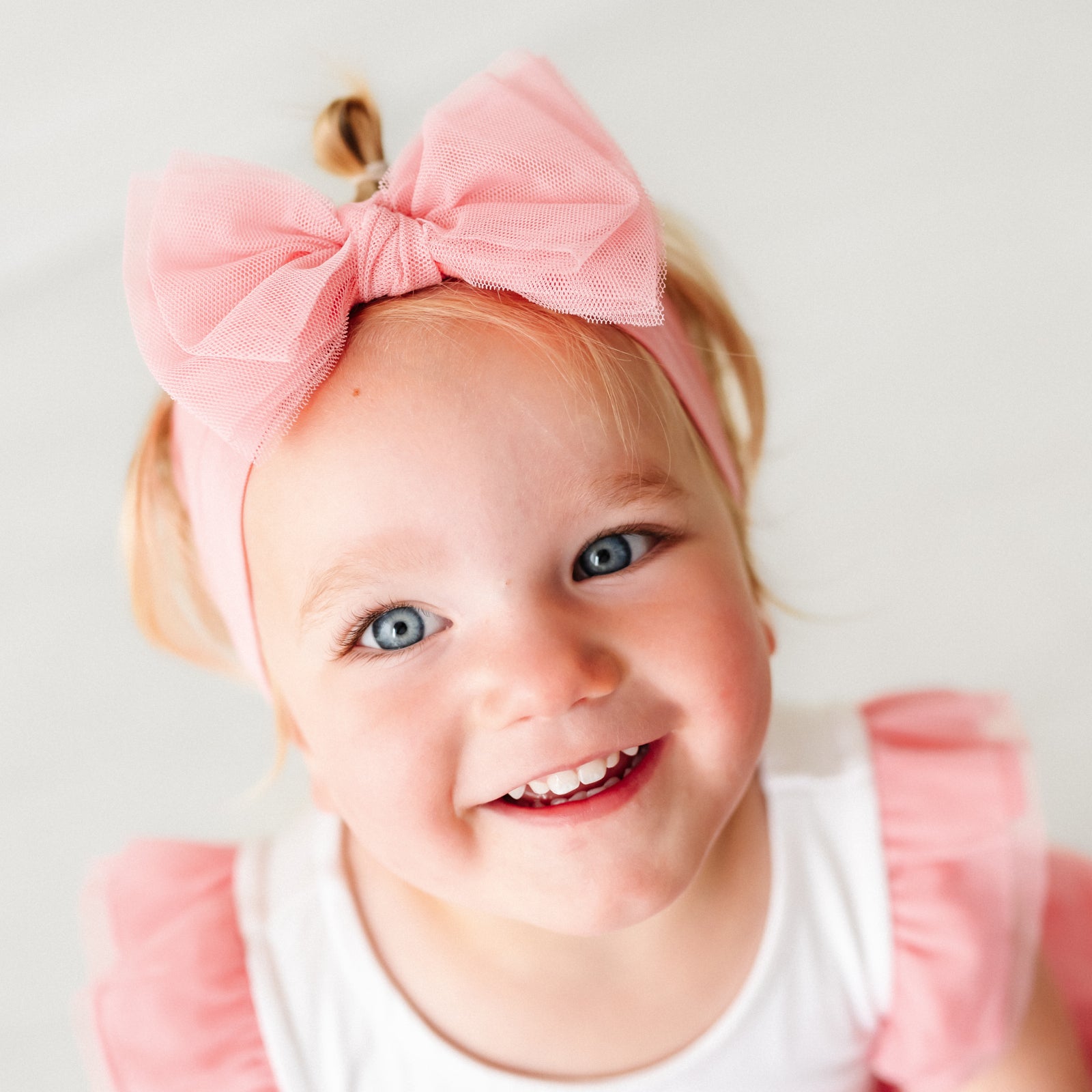 Alternate close up image of a child wearing a Pink tulle luxe bow headband