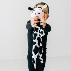 Child holding out a Charlie the Cow lovey