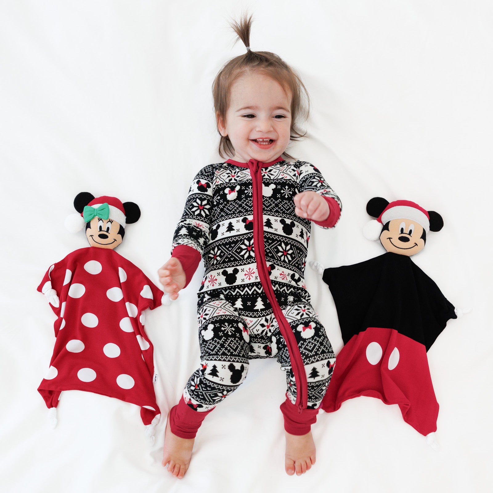 Child wearing a Mickey Fair Isle zippy next to a Mickey and Minnie lovey