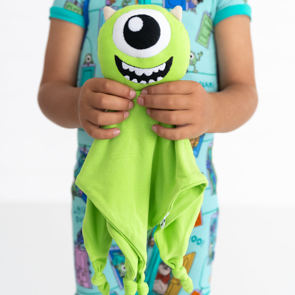 Close up image of child holding the Disney Monsters, Inc. Mike Wazowski Lovey