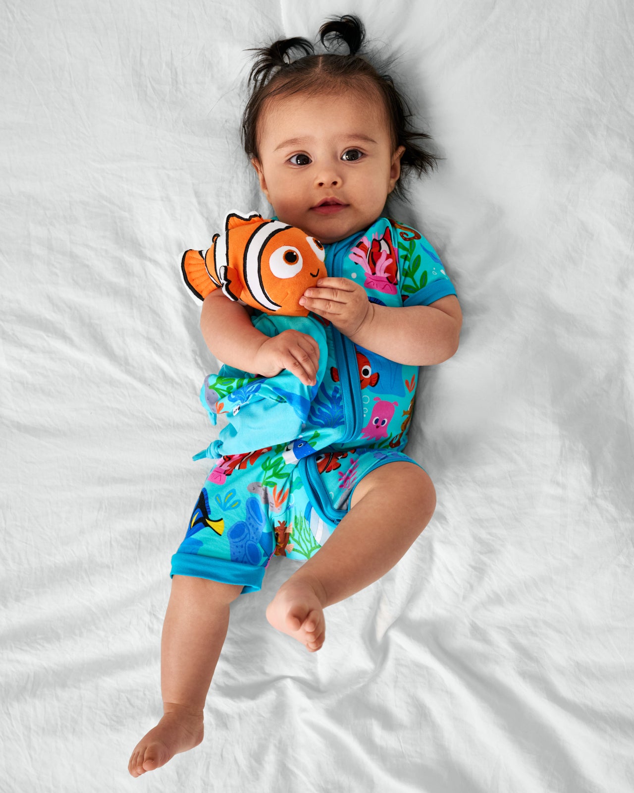 Baby wearing the Nemo's Reef Bamboo zippy holding the Disney Nemo Lovey