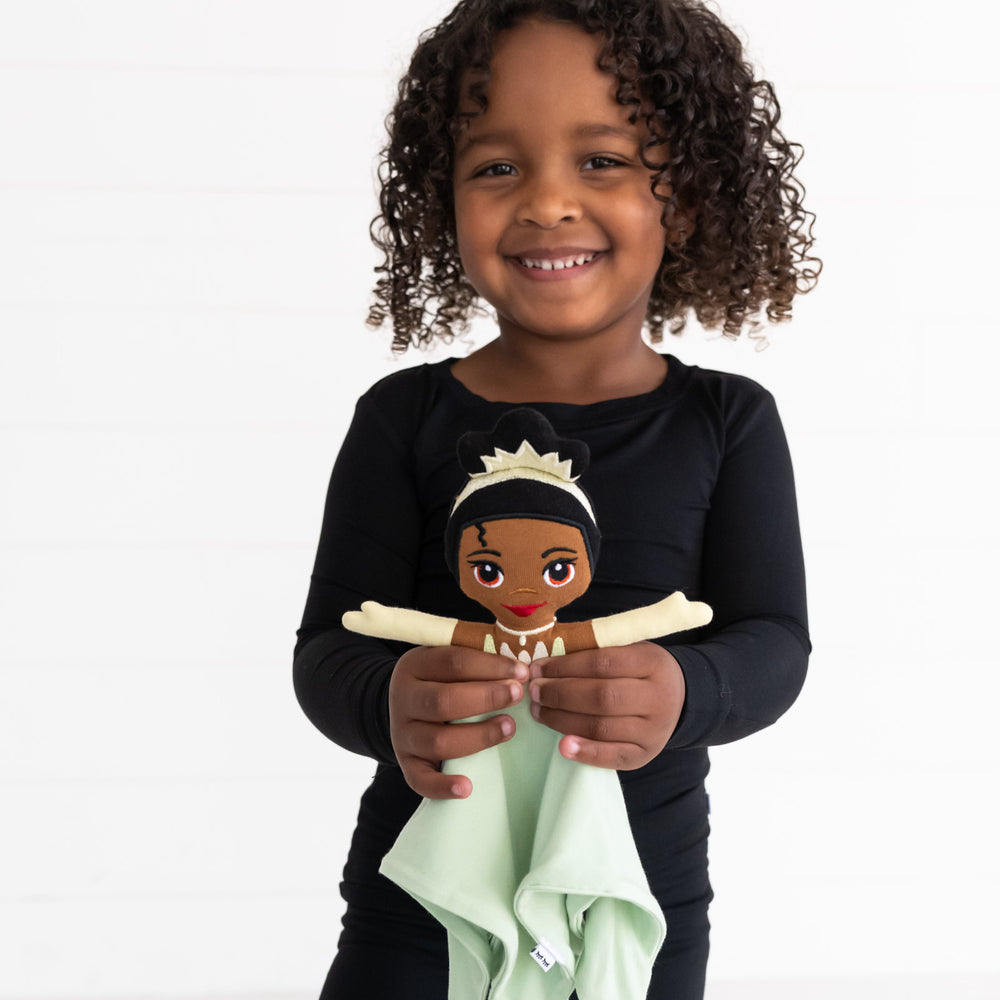 image of a child holding up a Princess Tiana Lovey