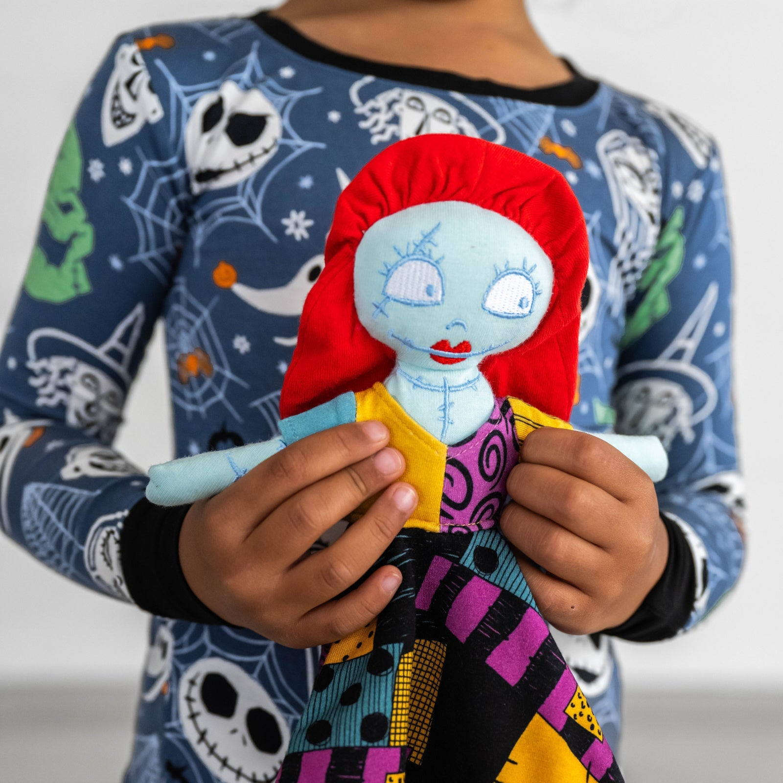 image of a child holding up a Sally lovey