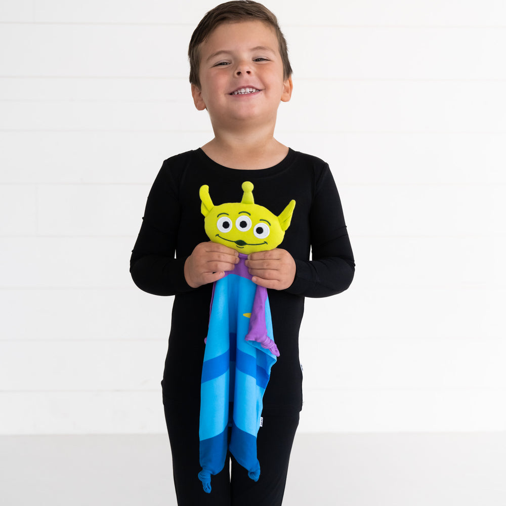 Alternate image of a child holding up a Disney Toy Story Alien lovey