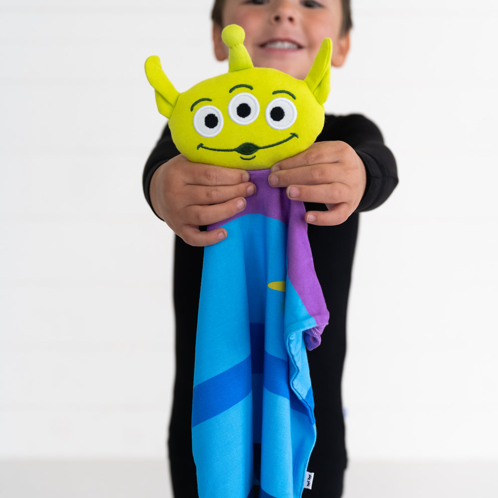 image of a child holding out an Alien lovey