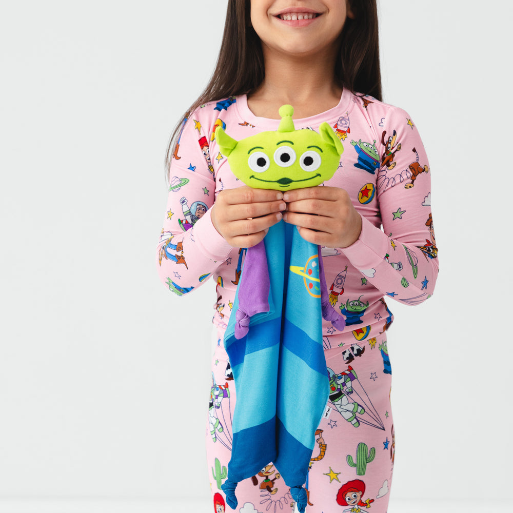 Image of a child holding an Alien lovey wearing a Toy Story Stars two piece pj set