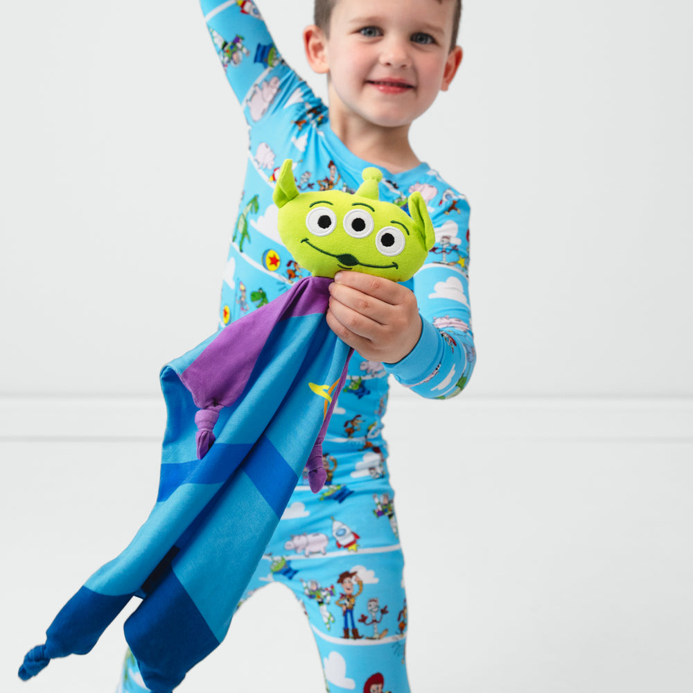 Image of a child holding an Alien lovey wearing a Toy Story Pals two piece pj set