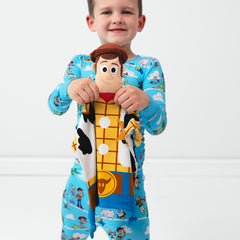 Image of a child holding out a Woody Lovey wearing a Toy Story Pals two piece