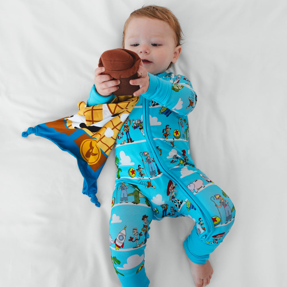 Image of a child holding out a Woody Lovey wearing a Toy Story Pals zippy