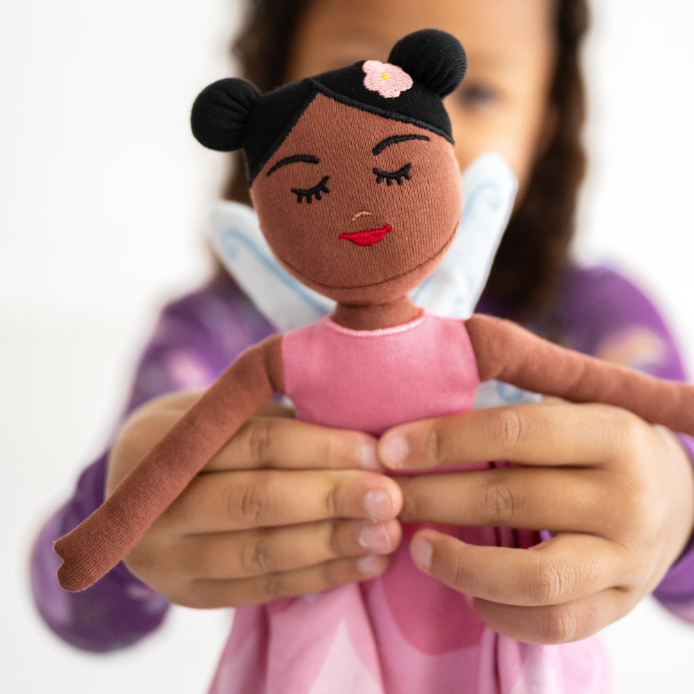 Close up image of child holding the Flora the Pink Fairy Sleepyhead Lovey