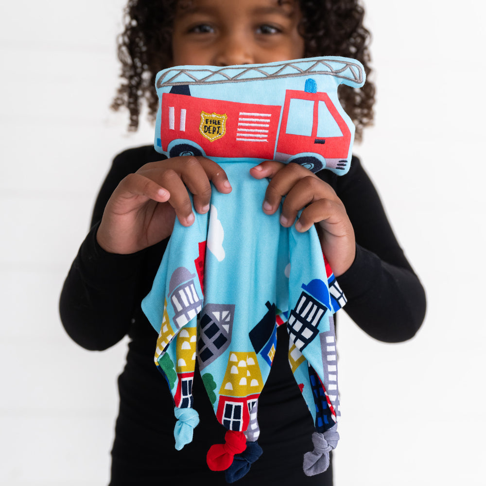 image of a child holding up a Franklin the Fire Truck police car