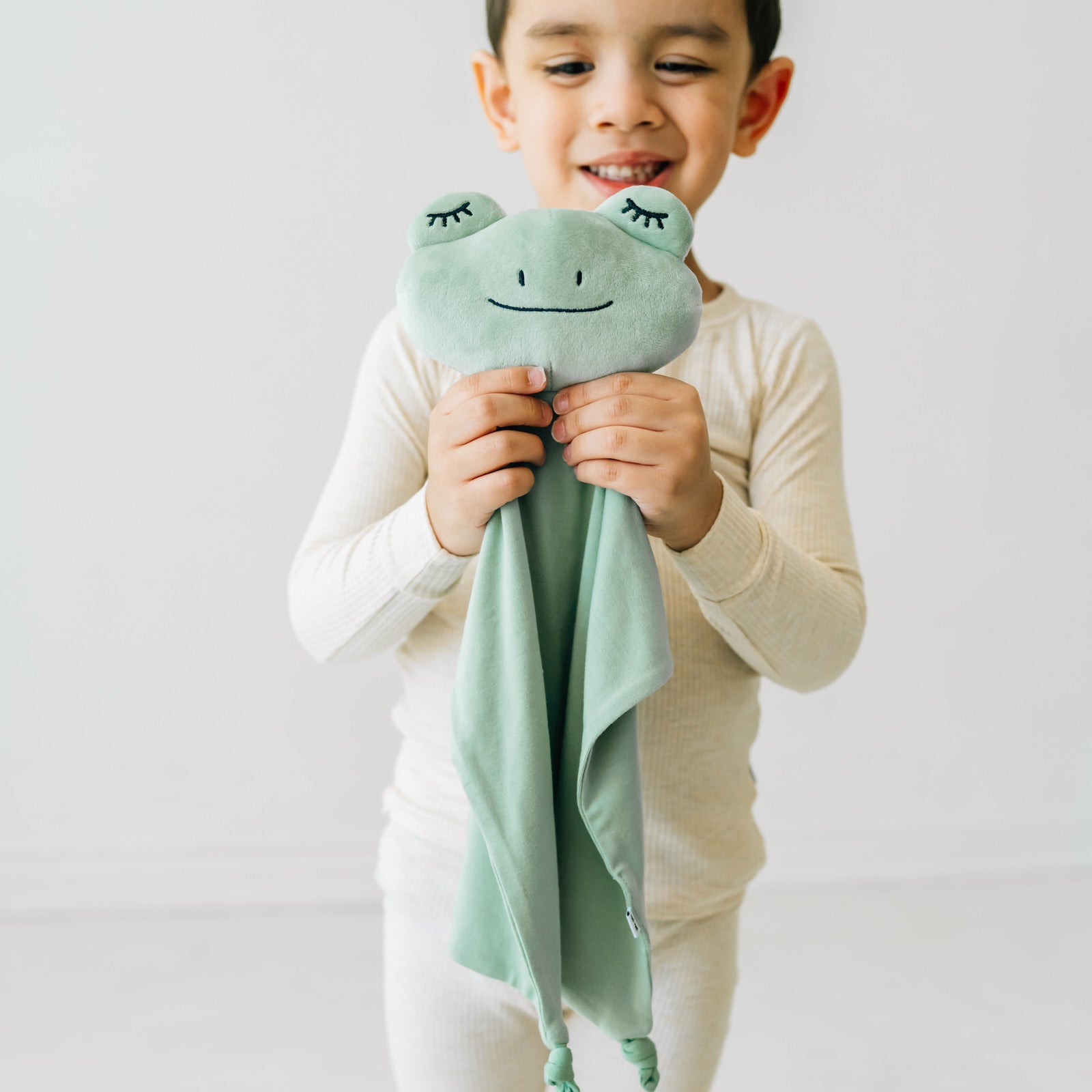 image of child with frog lovey