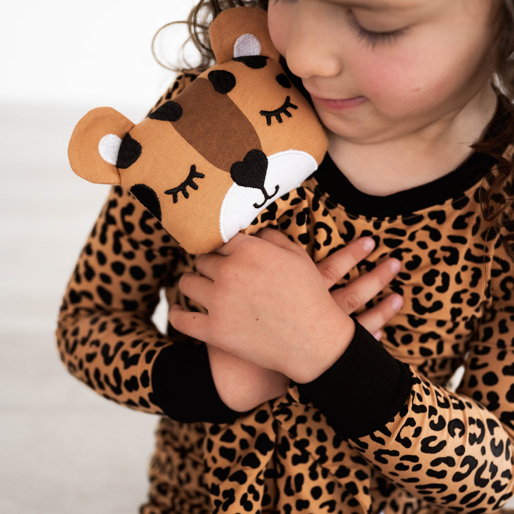 Close up image of girl holding Dash the Leopard Sleepyhead Lovey