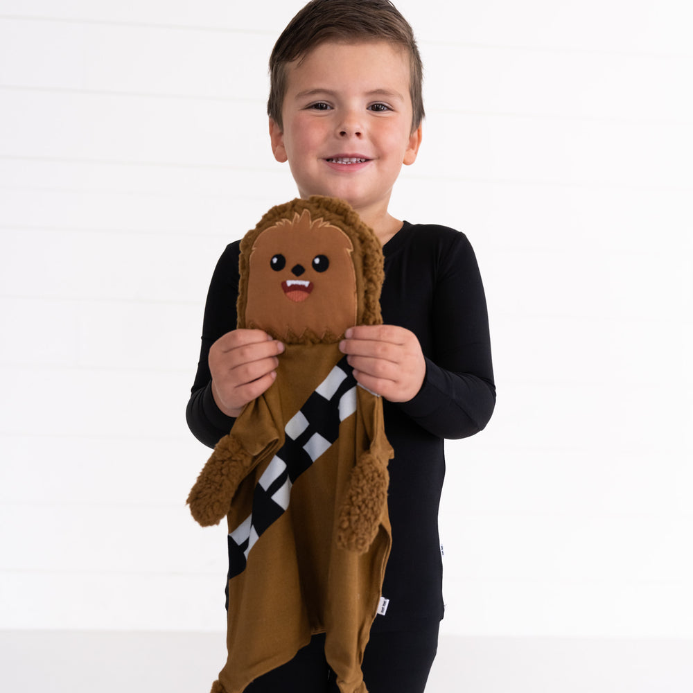 close up image of a child holding up a Chewbacca lovey